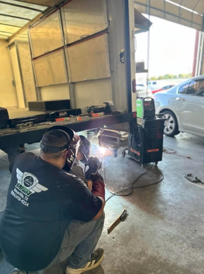 A Town Auto technician welding a trailer frame in the shop